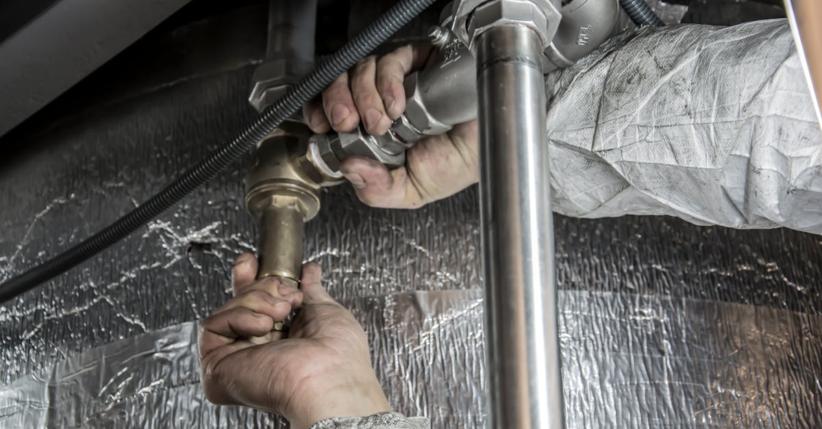 close up of a plumber s hands installing steel pipes indoors showcasing skilled manual work